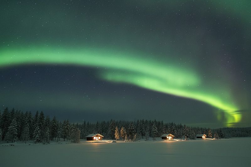 Northern lights over a frozen lake near Rovaniemi