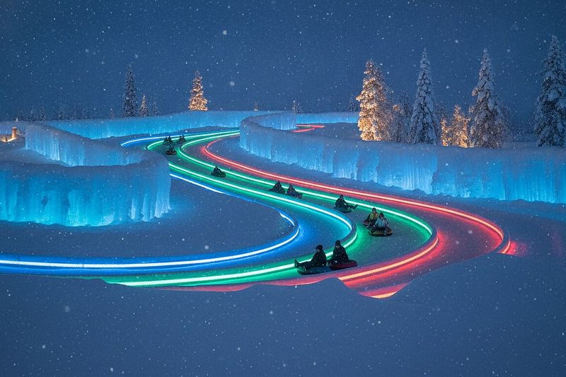 The ice slide of Snowman World lit up after dark